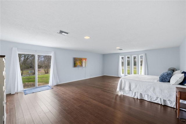 unfurnished bedroom with visible vents, multiple windows, and wood finished floors