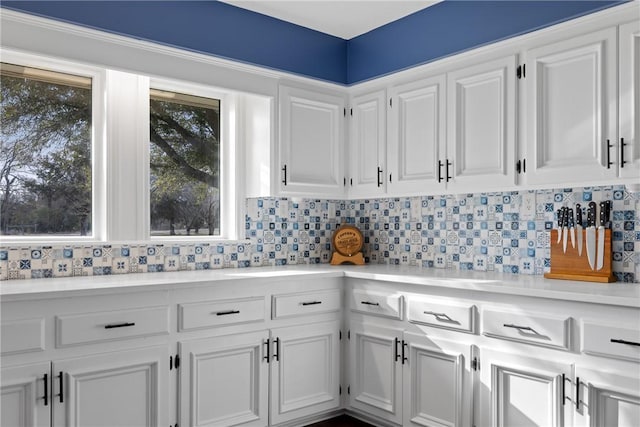 kitchen featuring backsplash, white cabinets, and light countertops