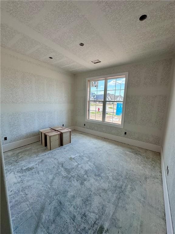 carpeted empty room with baseboards, a textured ceiling, and a textured wall