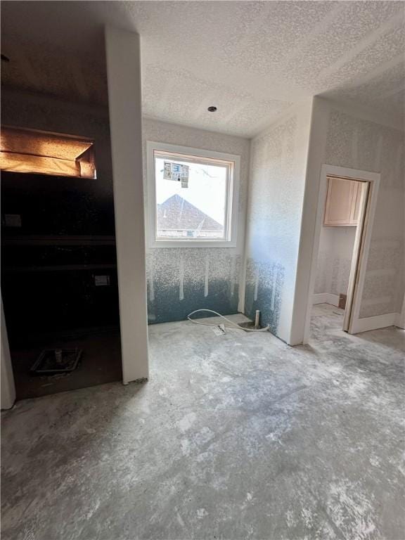 unfurnished bedroom with unfinished concrete floors and a textured ceiling