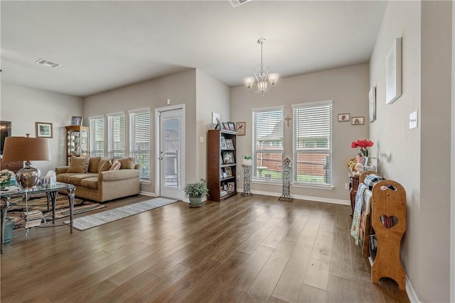 living room with a notable chandelier, plenty of natural light, and dark hardwood / wood-style floors