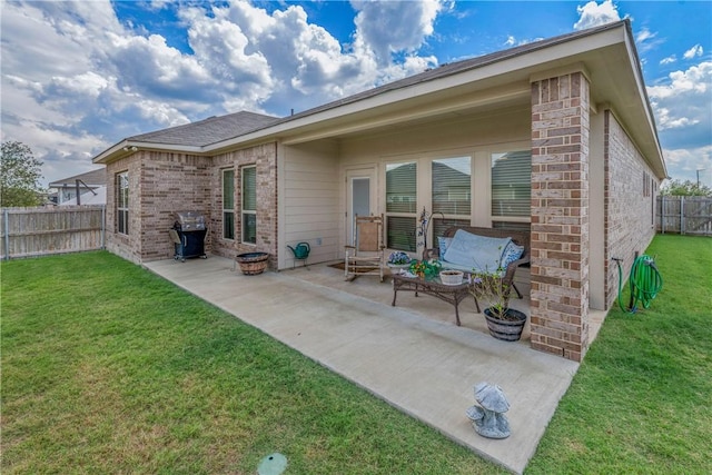 back of house featuring a lawn and a patio