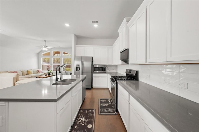 kitchen with tasteful backsplash, lofted ceiling, dark wood-style flooring, stainless steel appliances, and a sink