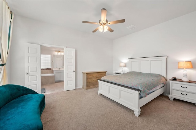 bedroom featuring a ceiling fan, light carpet, and connected bathroom
