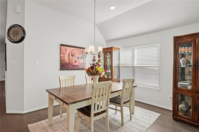 dining area with baseboards, vaulted ceiling, a notable chandelier, and wood finished floors