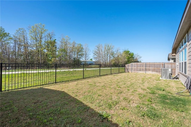 view of yard featuring central AC and a fenced backyard