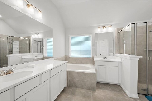 full bathroom with a stall shower, tile patterned floors, lofted ceiling, and a sink