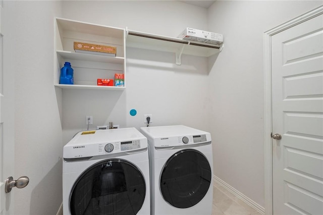 laundry room with light tile patterned flooring, baseboards, washer and dryer, and laundry area
