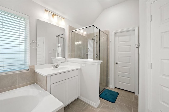 bathroom featuring tile patterned floors, vanity, lofted ceiling, a stall shower, and a garden tub