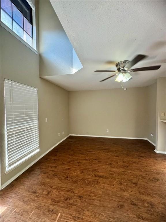 spare room with a textured ceiling, ceiling fan, and dark wood-type flooring