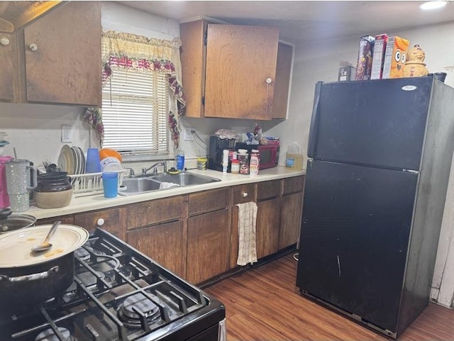 kitchen with sink, black appliances, and dark hardwood / wood-style floors