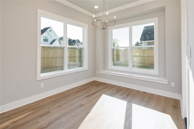 unfurnished dining area featuring ornamental molding, a chandelier, and light wood-type flooring