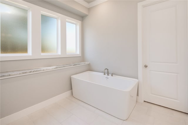 bathroom featuring a tub to relax in, tile patterned floors, and ornamental molding