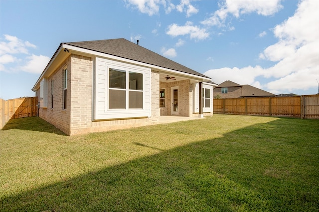 rear view of property with a lawn, ceiling fan, and a patio