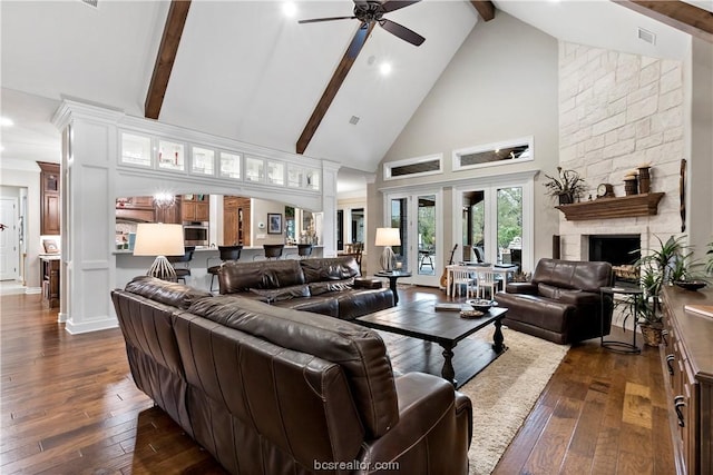 living room with a fireplace, beam ceiling, dark hardwood / wood-style flooring, and high vaulted ceiling