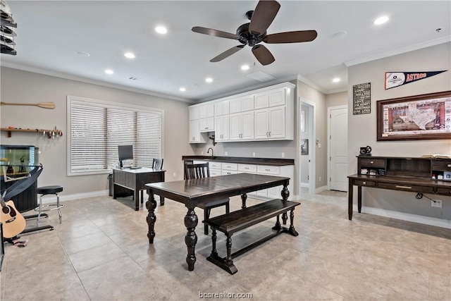 tiled dining space featuring ceiling fan, ornamental molding, and sink