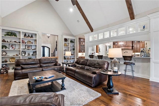 living room with built in shelves, ceiling fan, dark wood-type flooring, beamed ceiling, and high vaulted ceiling