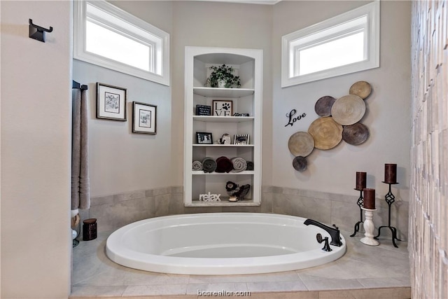 bathroom featuring tiled bath and plenty of natural light