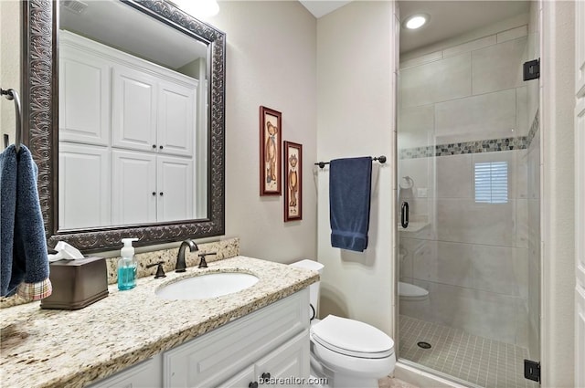 bathroom with vanity, toilet, and a shower with door