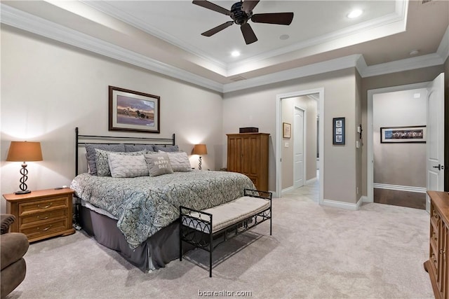 bedroom with light carpet, a tray ceiling, ceiling fan, and ornamental molding