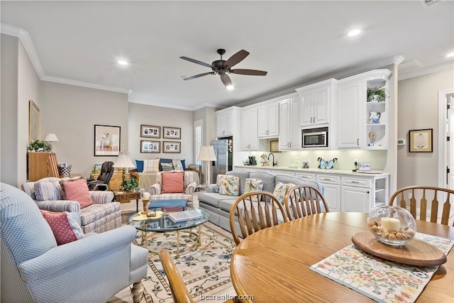 dining room featuring ceiling fan, sink, and ornamental molding