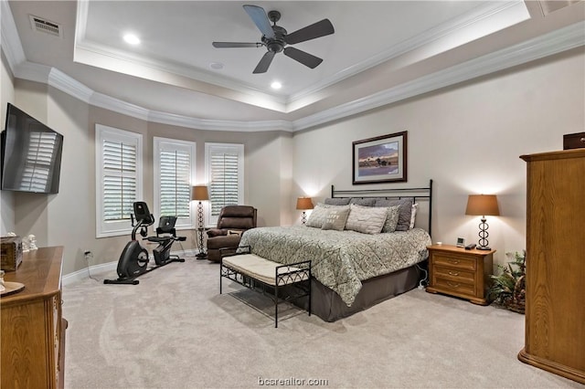 carpeted bedroom featuring a tray ceiling, ceiling fan, and ornamental molding