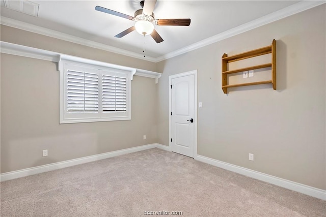 empty room with crown molding, ceiling fan, and light colored carpet