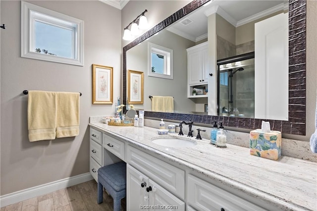 bathroom with vanity, hardwood / wood-style flooring, a wealth of natural light, and ornamental molding