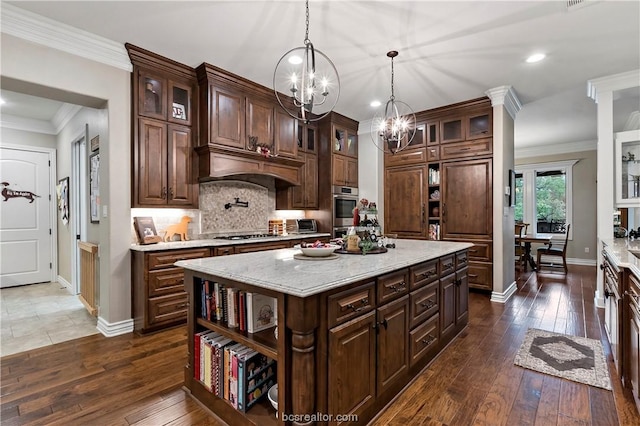 kitchen with dark brown cabinets, a center island, dark hardwood / wood-style floors, and decorative light fixtures