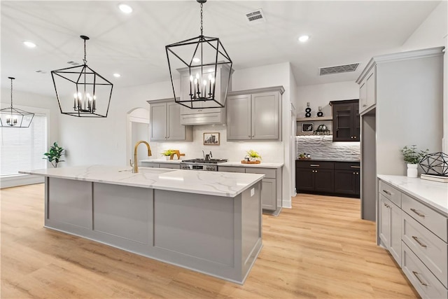 kitchen featuring decorative light fixtures, tasteful backsplash, gray cabinetry, and a large island