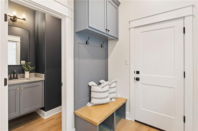 mudroom with light hardwood / wood-style flooring and sink