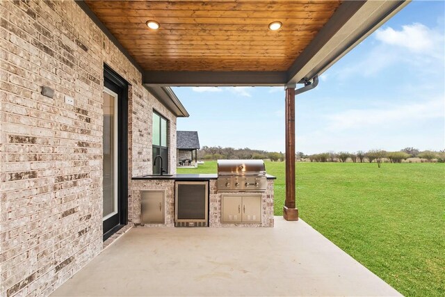 view of patio / terrace with an outdoor kitchen, a rural view, area for grilling, and sink