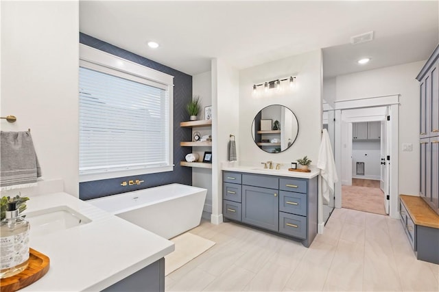 bathroom featuring vanity and a washtub