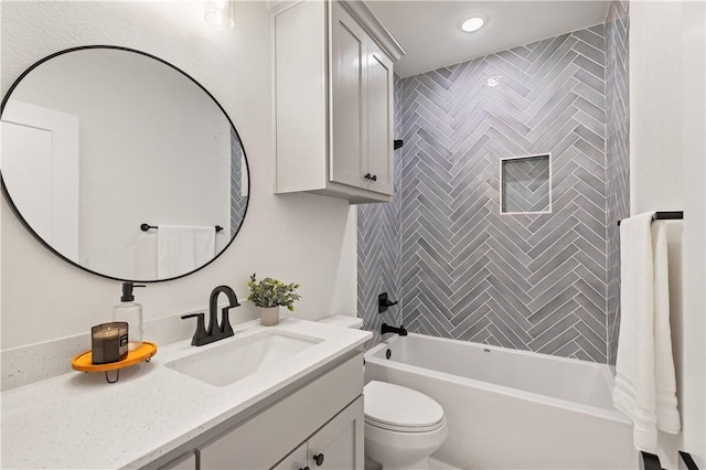 full bathroom with tiled shower / bath combo, toilet, and vanity