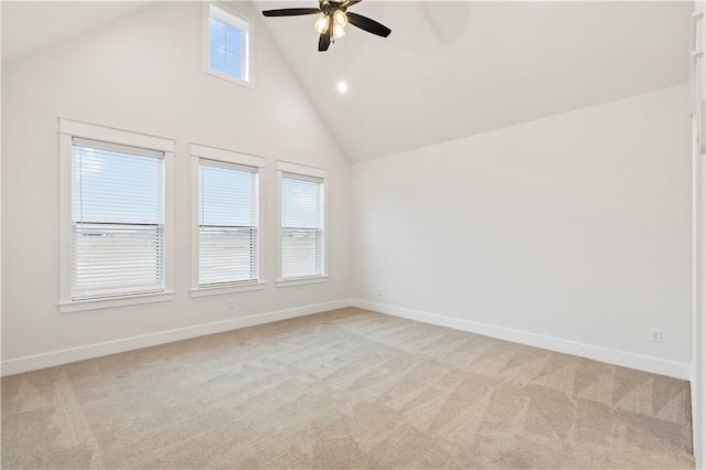 spare room with ceiling fan, high vaulted ceiling, and light carpet