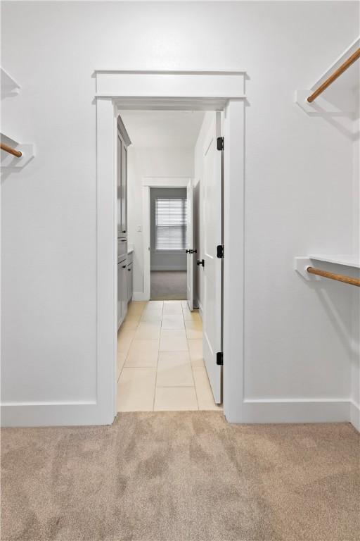 spacious closet featuring light colored carpet