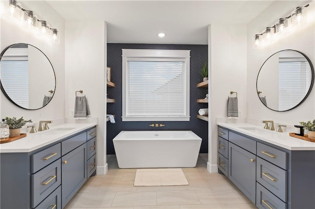 bathroom featuring tile patterned floors, a tub, and vanity