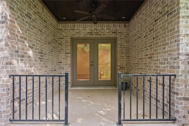 doorway to property with a patio, french doors, a ceiling fan, and brick siding