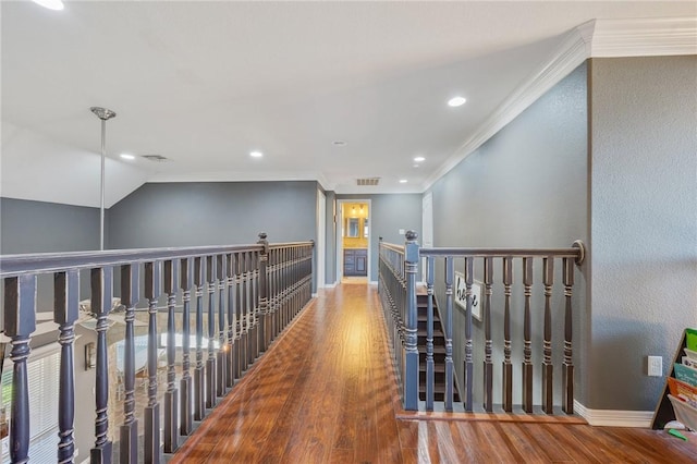 hall with crown molding, lofted ceiling, and wood-type flooring