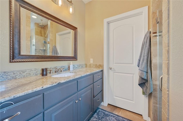 bathroom with an enclosed shower, vanity, and tile patterned floors