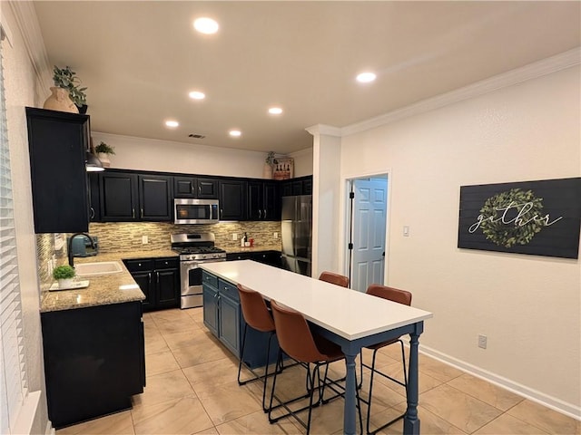 14504 Templemore Cv, Austin, TX 78717 - kitchen featuring a breakfast bar area, a sink, crown molding, decorative backsplash, and appliances with stainless steel finishes