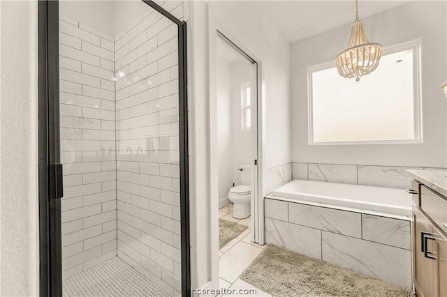 bathroom with vanity, toilet, tiled tub, and a chandelier