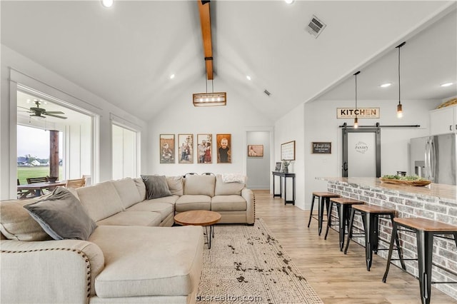 living room with high vaulted ceiling, light hardwood / wood-style flooring, ceiling fan, a barn door, and beam ceiling