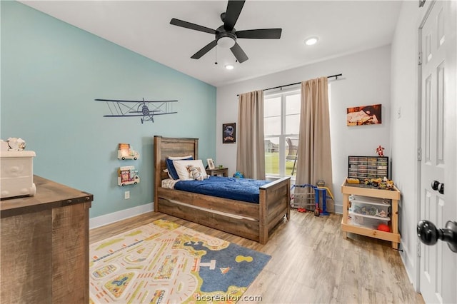 bedroom with ceiling fan, vaulted ceiling, and hardwood / wood-style flooring