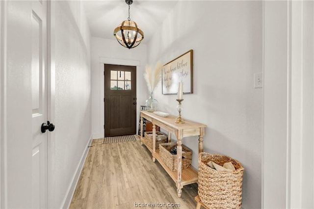 entryway with hardwood / wood-style flooring and a chandelier