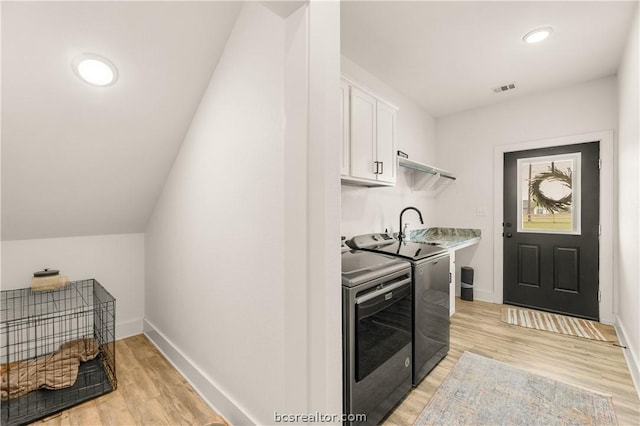 kitchen featuring lofted ceiling, light hardwood / wood-style floors, white cabinetry, and separate washer and dryer