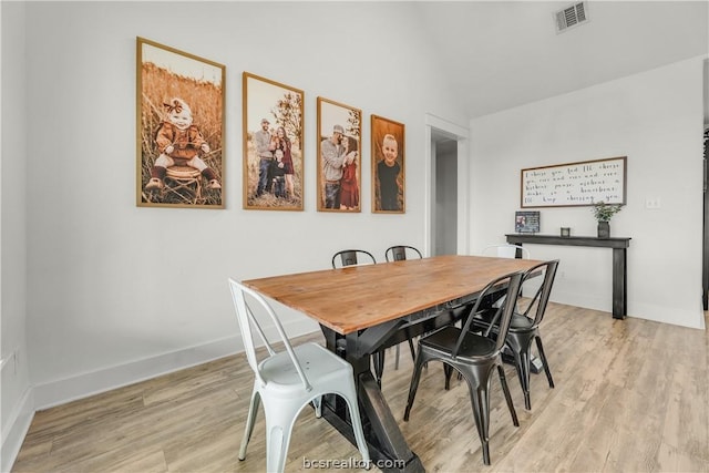 dining area featuring light hardwood / wood-style floors and lofted ceiling