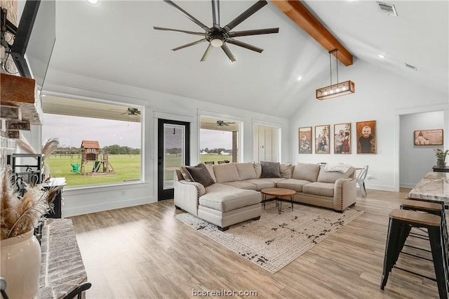 living room featuring beamed ceiling, a brick fireplace, light hardwood / wood-style floors, and high vaulted ceiling