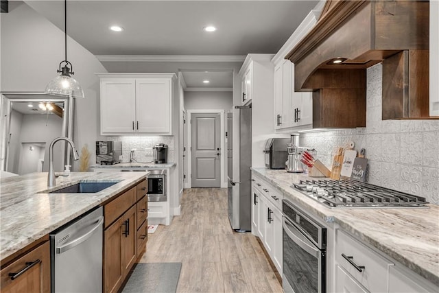 kitchen featuring sink, stainless steel appliances, white cabinets, and light stone countertops