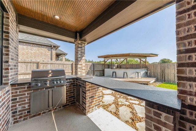 view of patio with an outdoor kitchen, an outdoor bar, and area for grilling